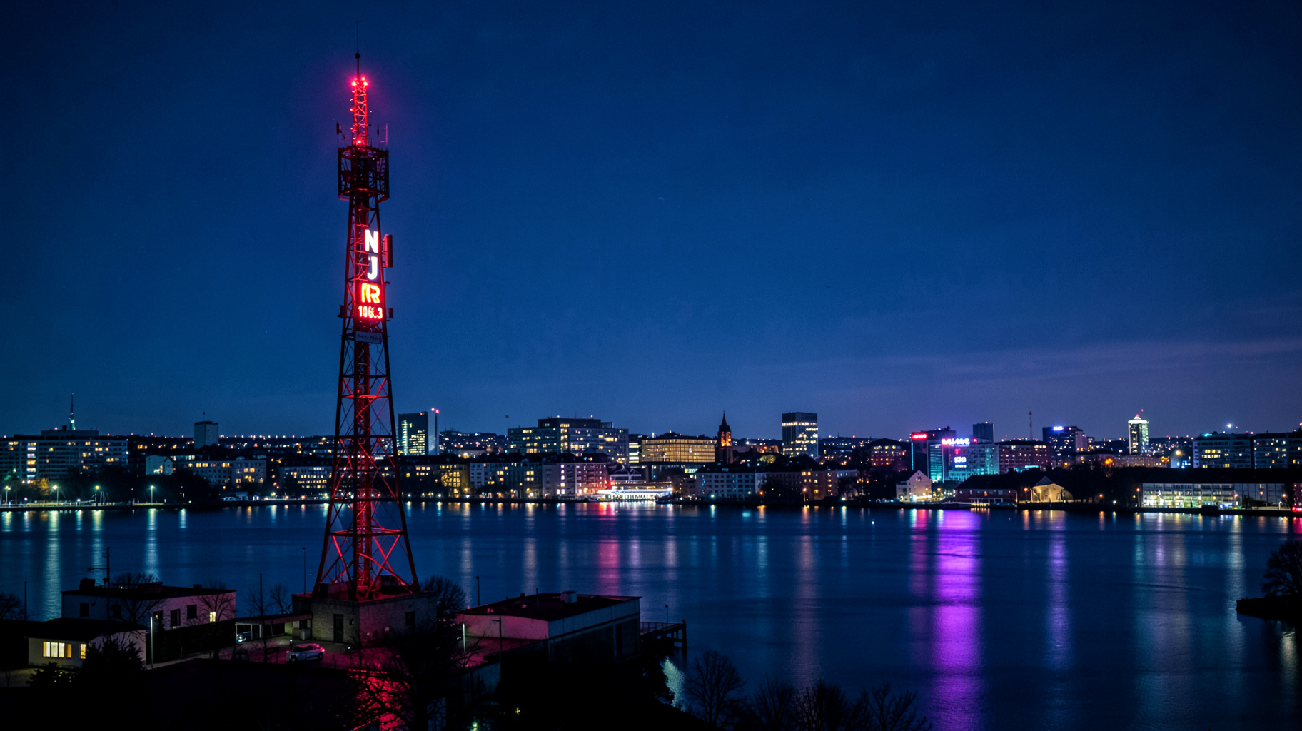 A Stockholm night skyline with a radio broadcast tower and a neon sign reading NRJ 106.3