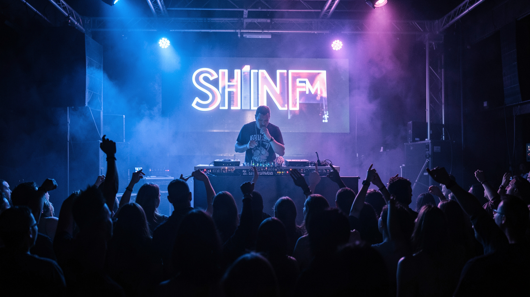 A packed London UK garage club night with a sign behind the DJ booth reading Shine FM