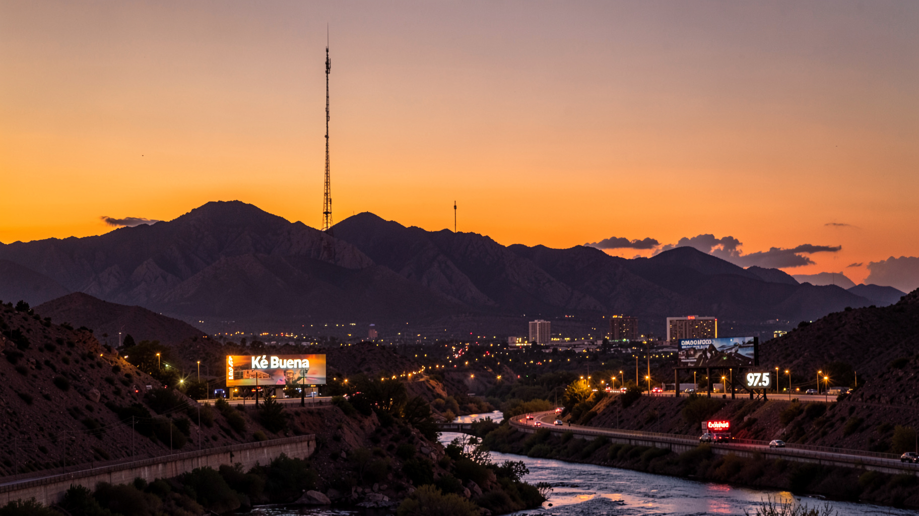 The Franklin Mountains at sunset with a radio tower silhouetted above the twin cities of El Paso and Ciudad Juárez, a Ké Buena 97.5 billboard glowing near the highway
