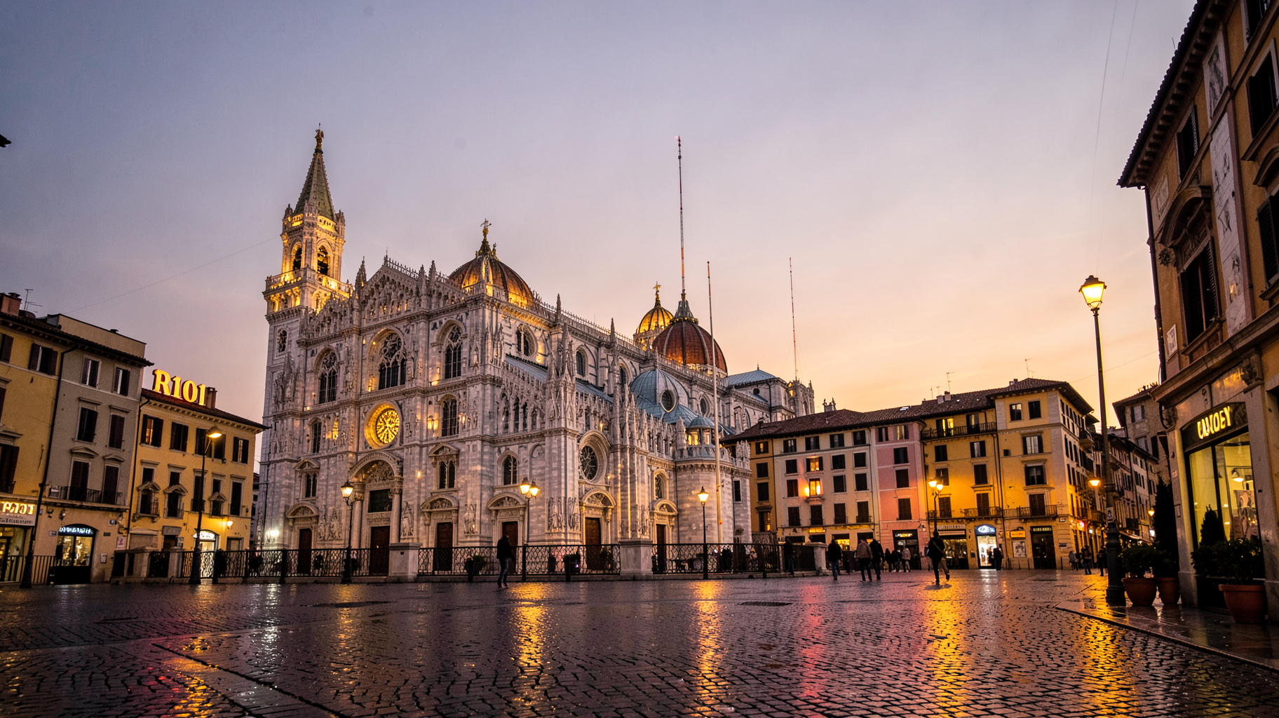The Milan Duomo illuminated at dusk with a radio antenna and a sign reading R101