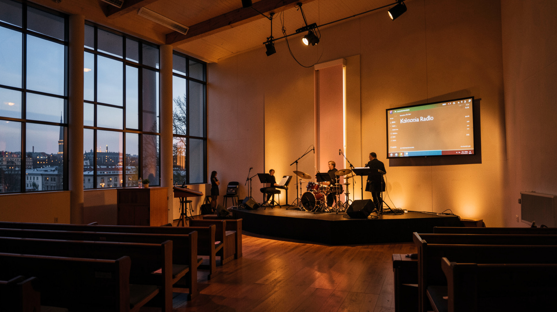 A warm church sanctuary in Hannover during an evening worship service with the city skyline visible through the windows