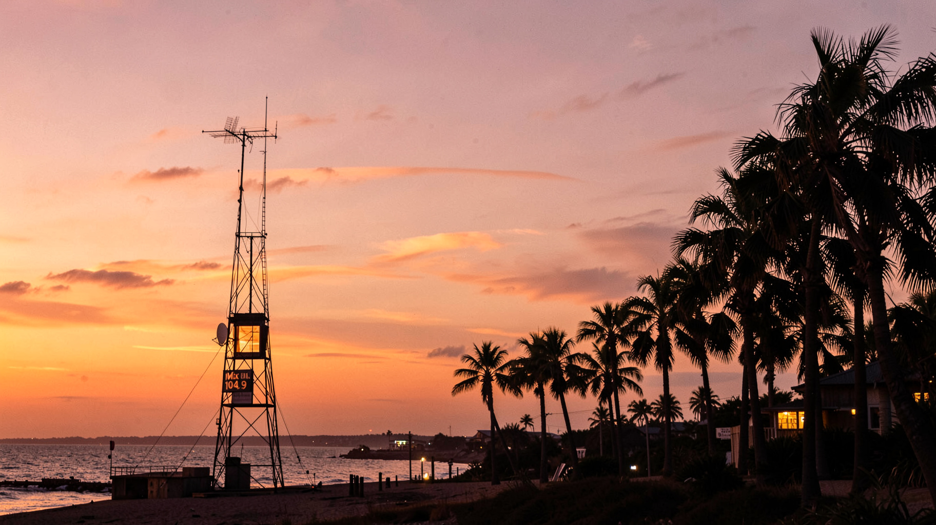 Sunset over Darwin's Mindil Beach with a radio tower silhouette and Mix 104.9 signage