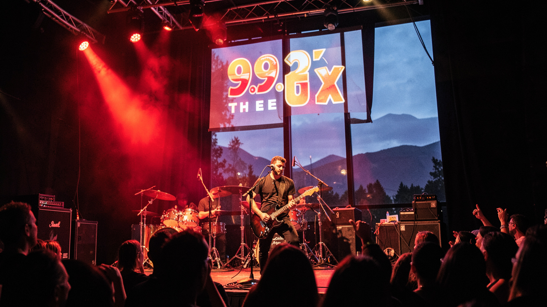 A packed Vancouver rock club stage at night with a backlit sign reading 99.3 THE FOX above the stage