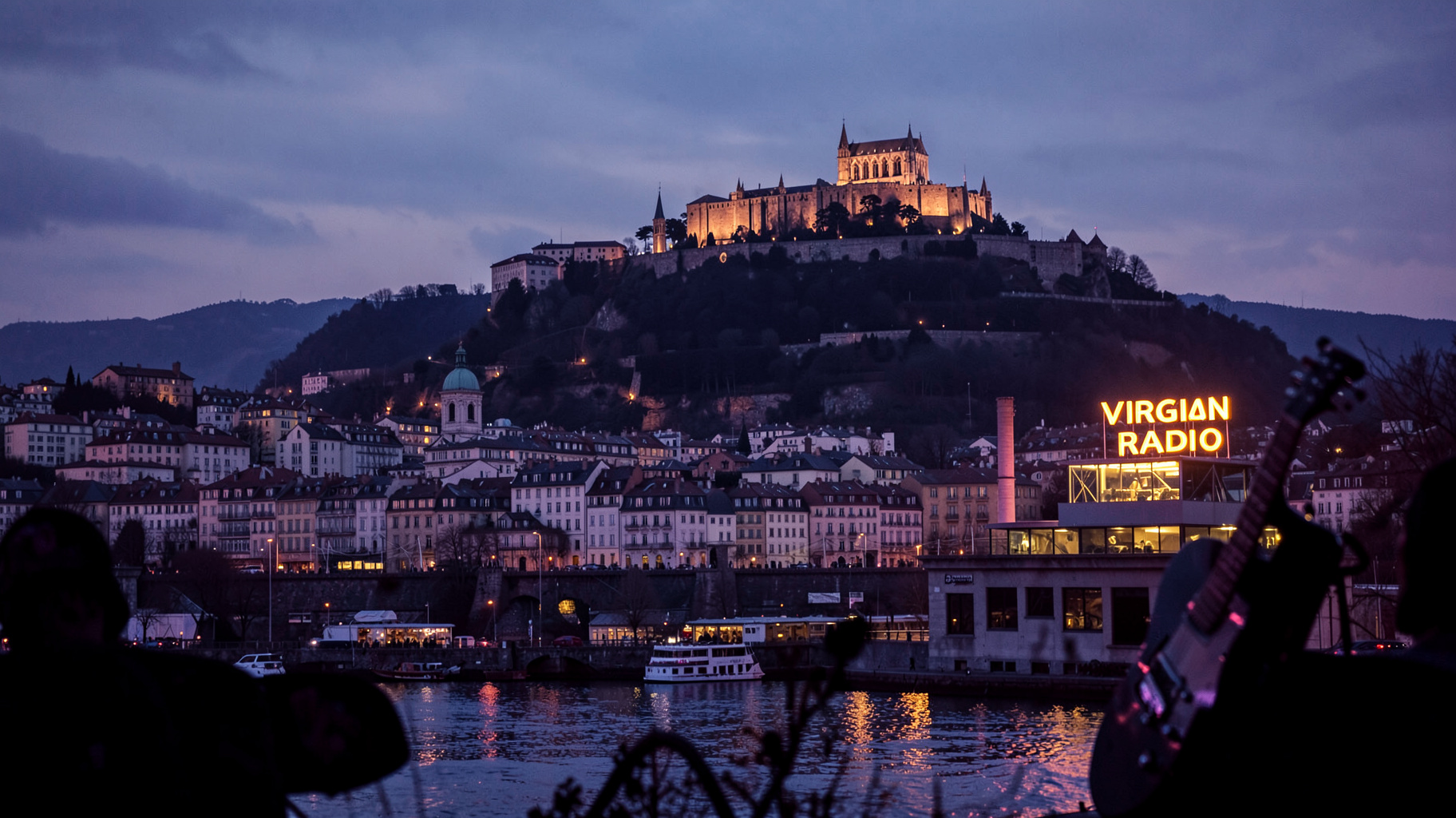 Lyon skyline at dusk with Notre-Dame de Fourvière and a glowing Virgin Radio sign