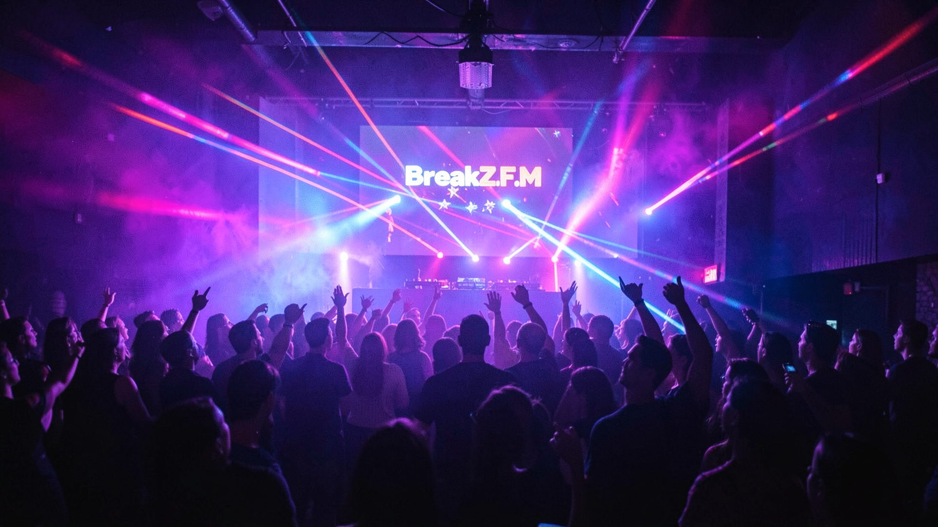 A packed German nightclub with laser lights over the dancefloor and a DJ booth screen reading BreakZ.FM