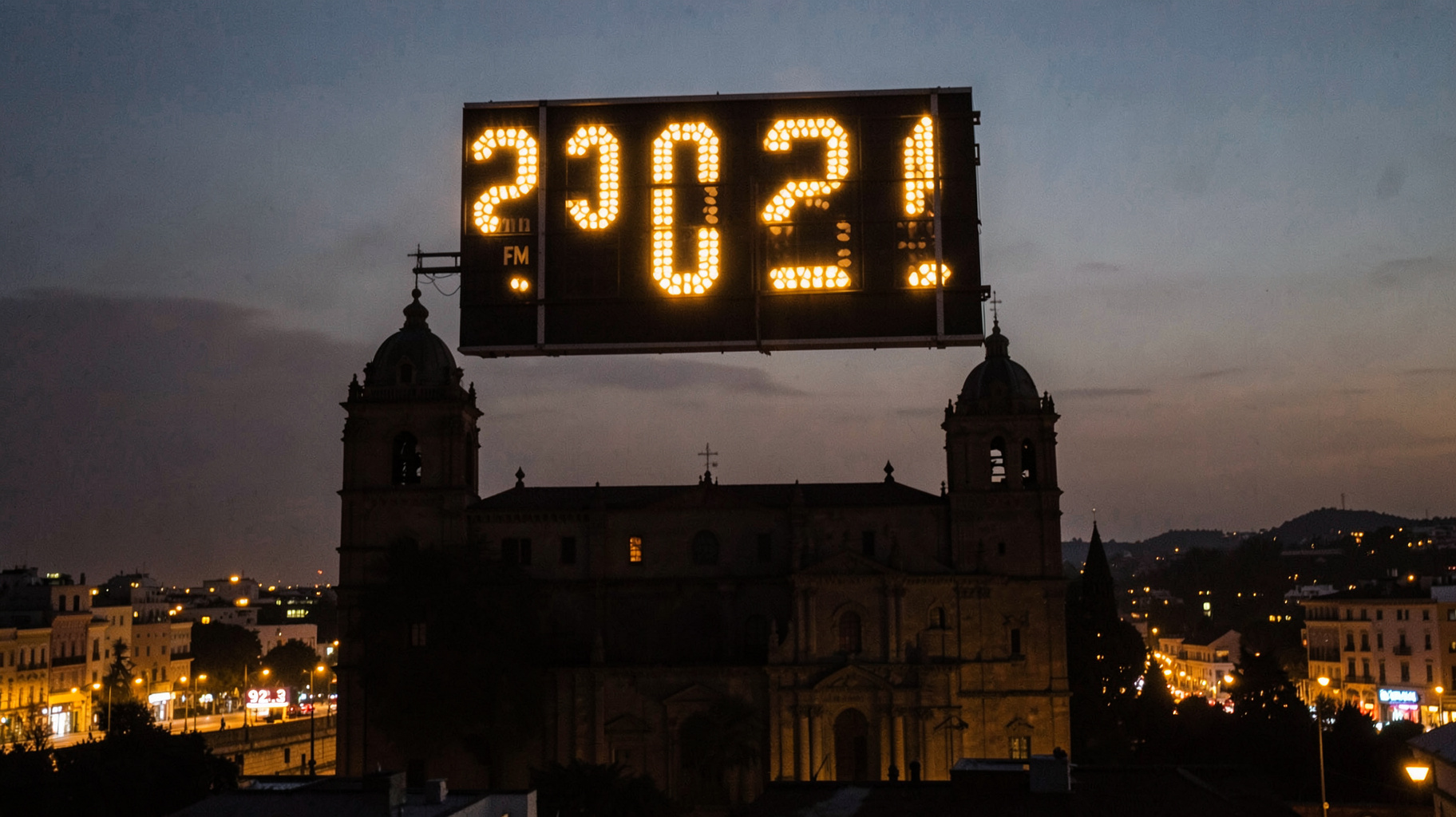 Morelia Cathedral at dusk with a giant flip-clock sign showing changing years and a marquee reading 92.3 FM, inspired by 2022 FM Morelia