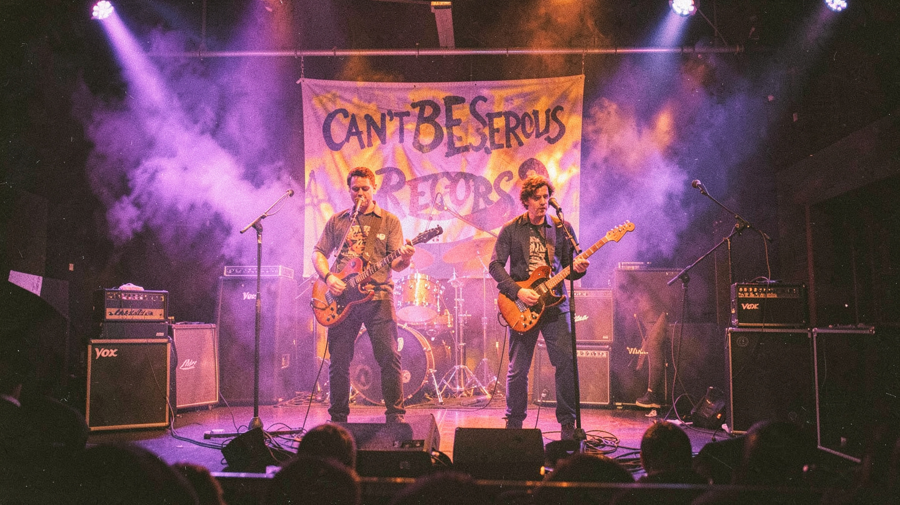 A psychedelic 1969-style rock club performance with a band on stage under swirling purple and orange lights