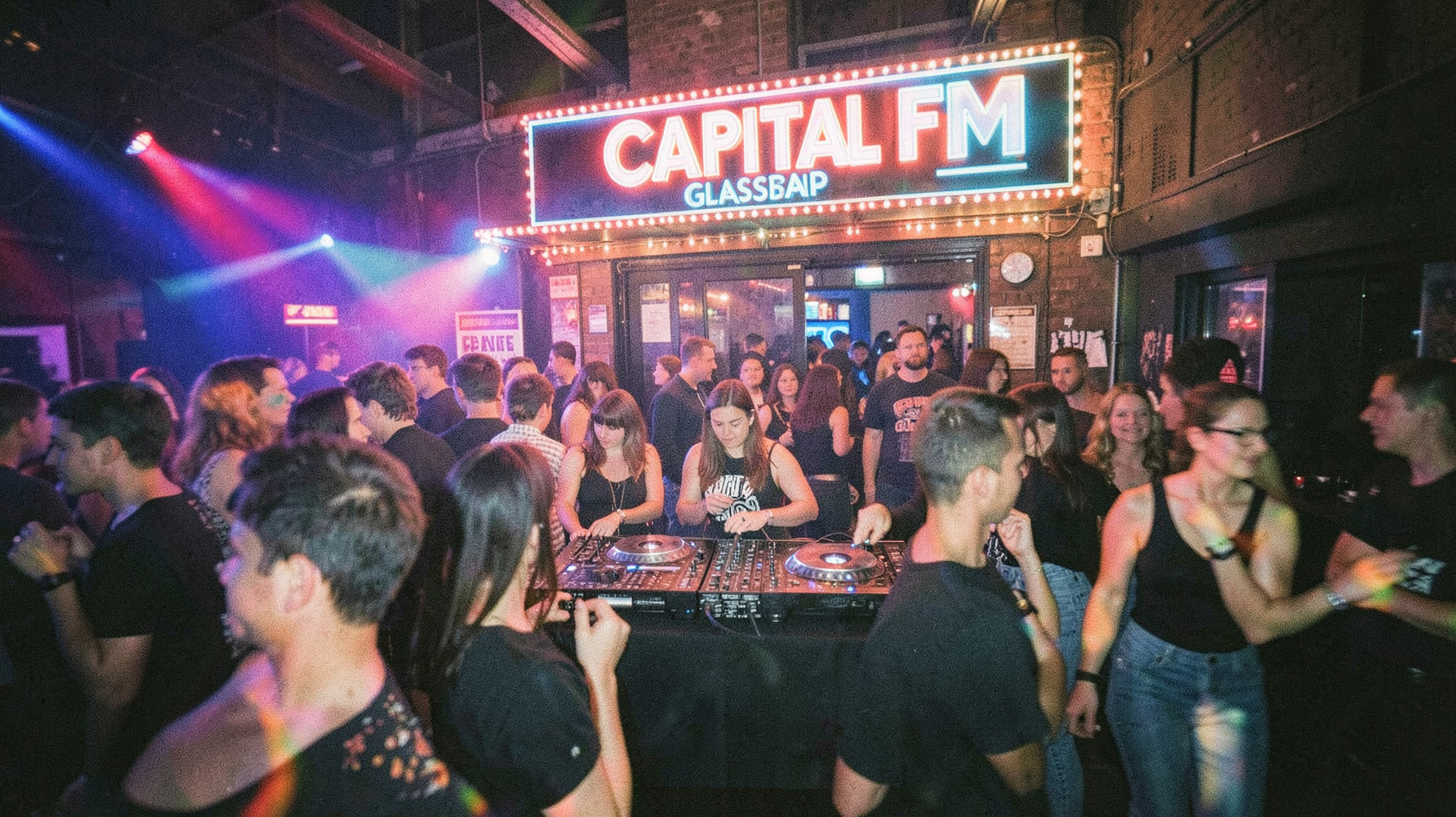 A late 1990s Glasgow nightclub scene with a sign reading Capital FM Glasgow