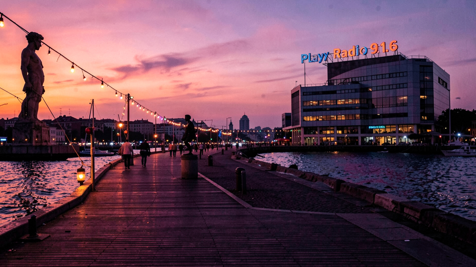 A Black Sea boardwalk in Constanta, Romania at sunset with a rooftop sign reading Play Radio 91.6