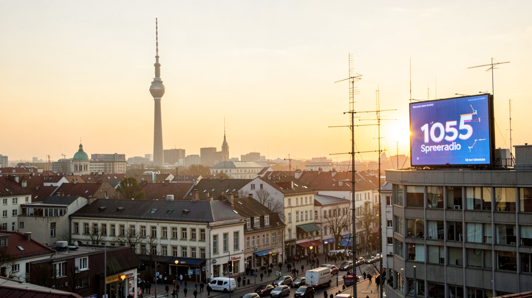 A Berlin morning cityscape with the Fernsehturm TV tower and a billboard reading 105'5 Spreeradio