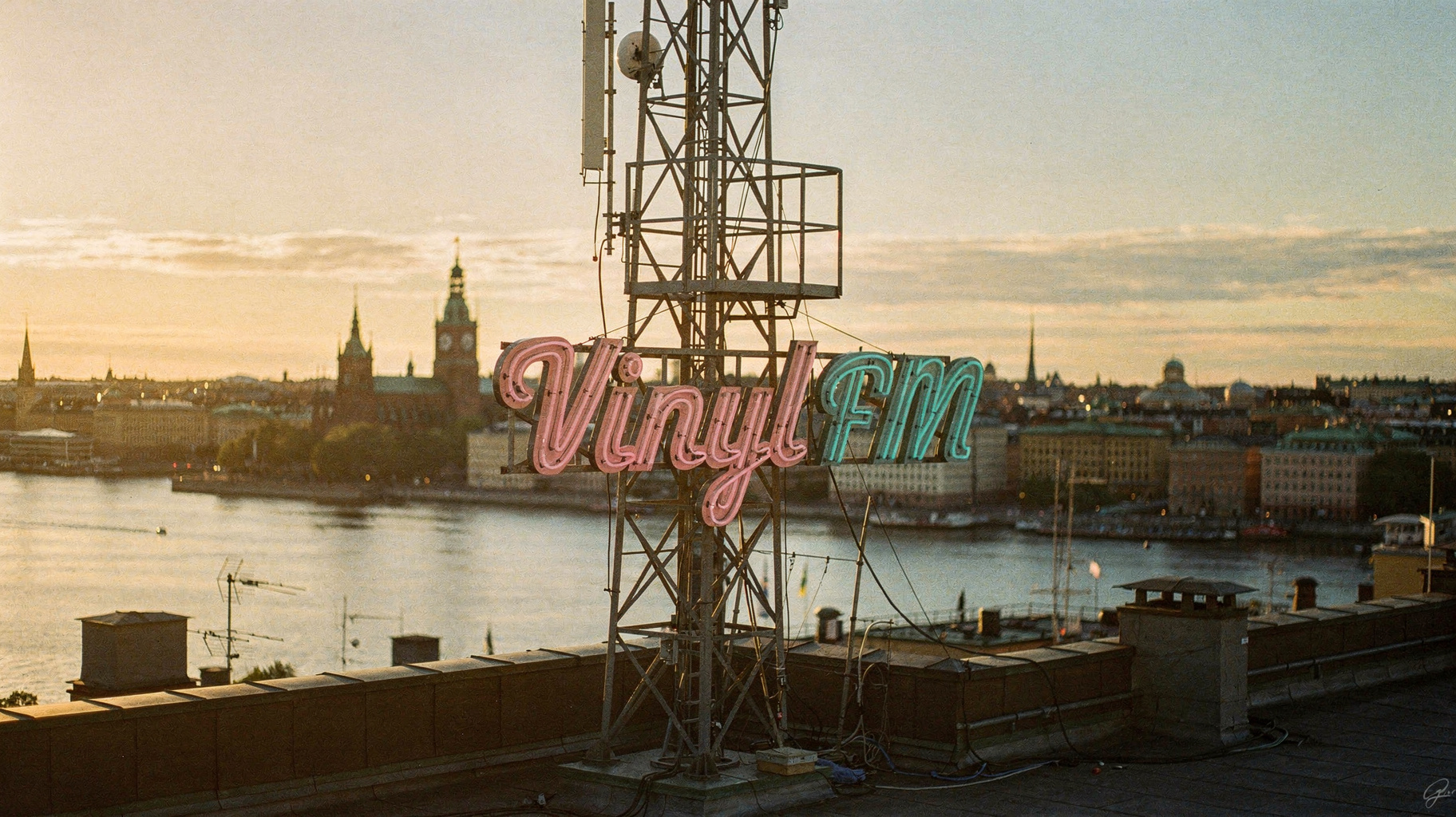 The Stockholm skyline at golden hour with a retro neon sign reading Vinyl FM, inspired by Vinyl FM