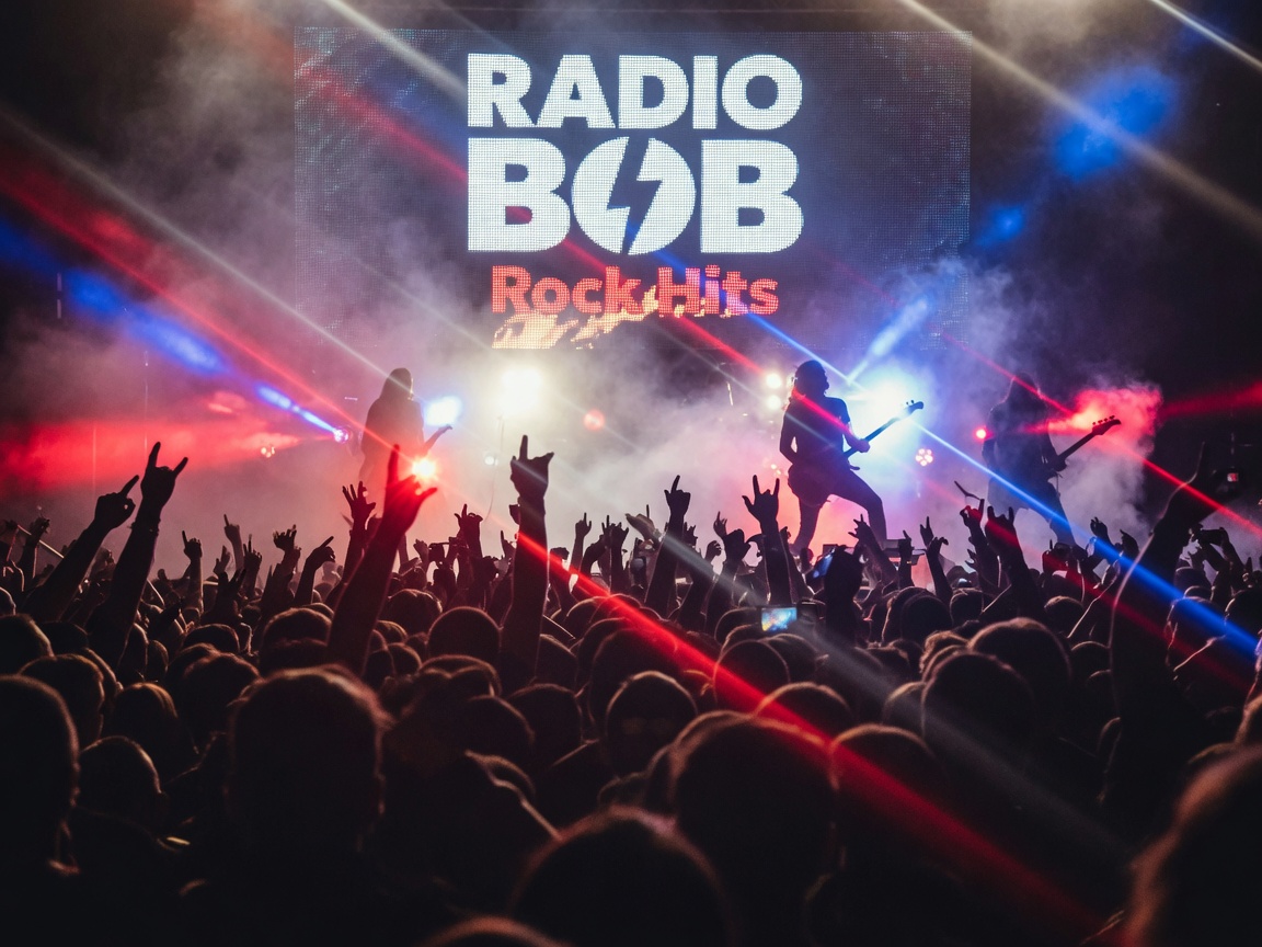 Concert crowd with hands raised beneath a large screen reading Radio BOB Rock Hits